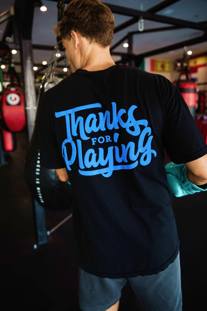 The back side of the blue logo tee worn at a gym.