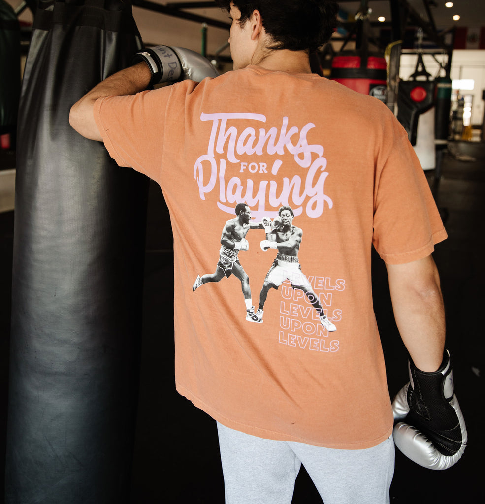 The back side of the Clay Levels Upon levels Fight shirt worn at a boxing gym.