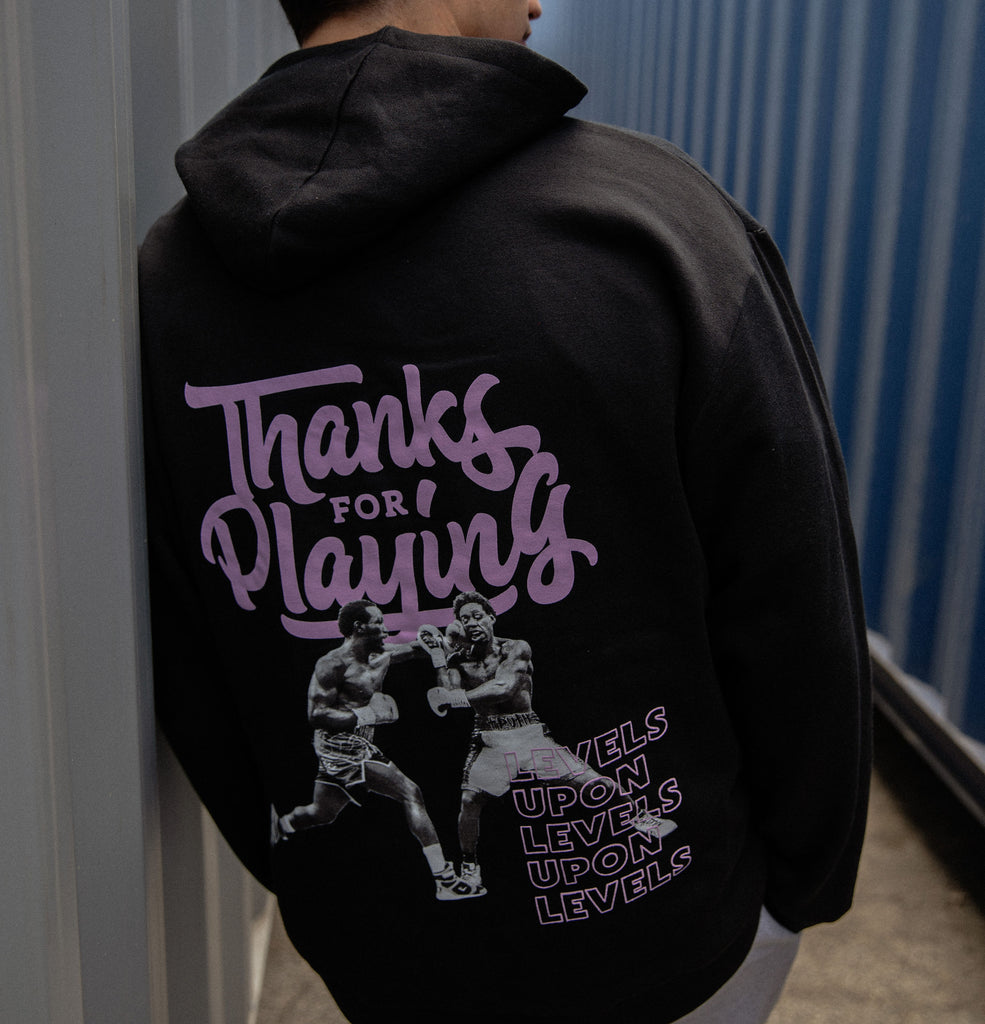 The back side of the Levels Upon levels Fight hoodie worn at outside.