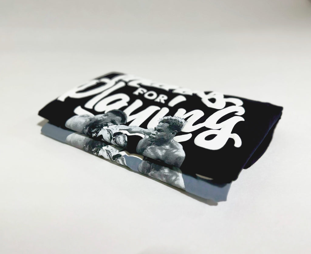 Black and grey The Dream shirts folded on top of each other.